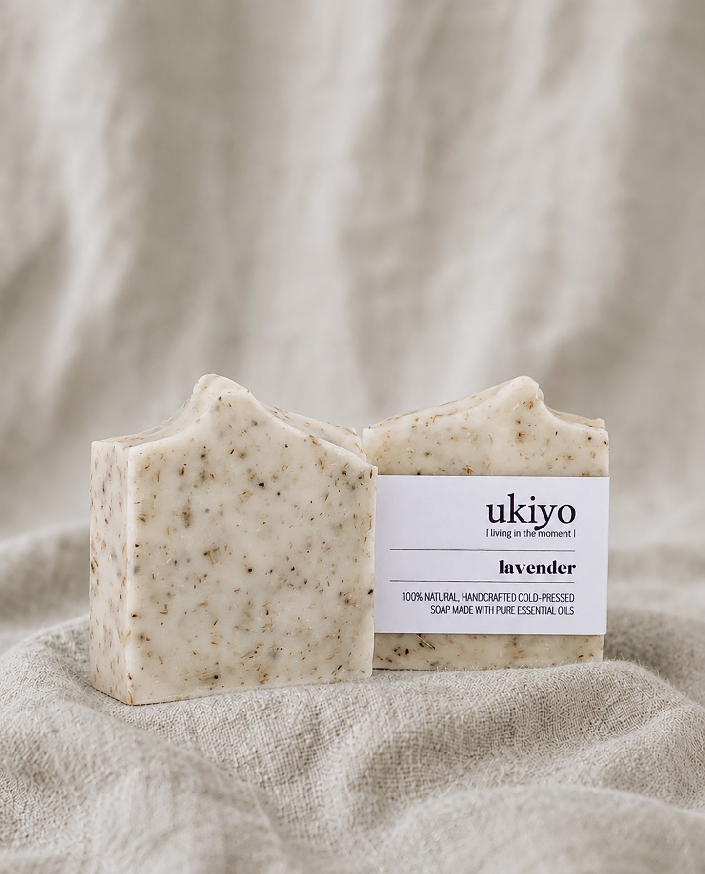 Bar of lavender soap with a 'ukiyo' label on a textured beige fabric background
