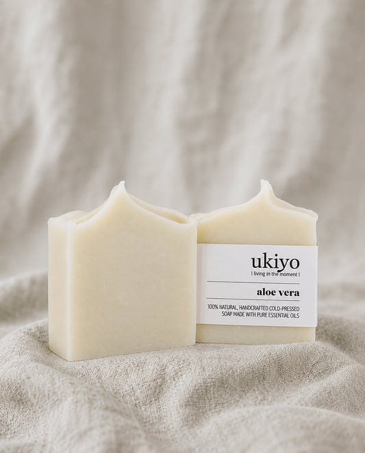aloe vera soap bar with a label on a beige fabric background