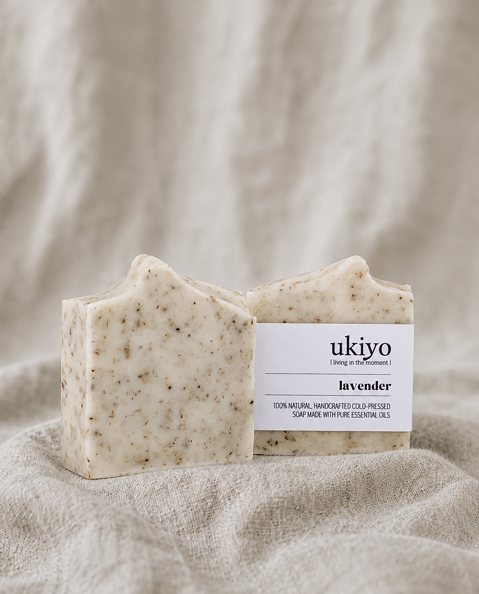 Bar of lavender soap with a 'ukiyo' label on a textured beige fabric background