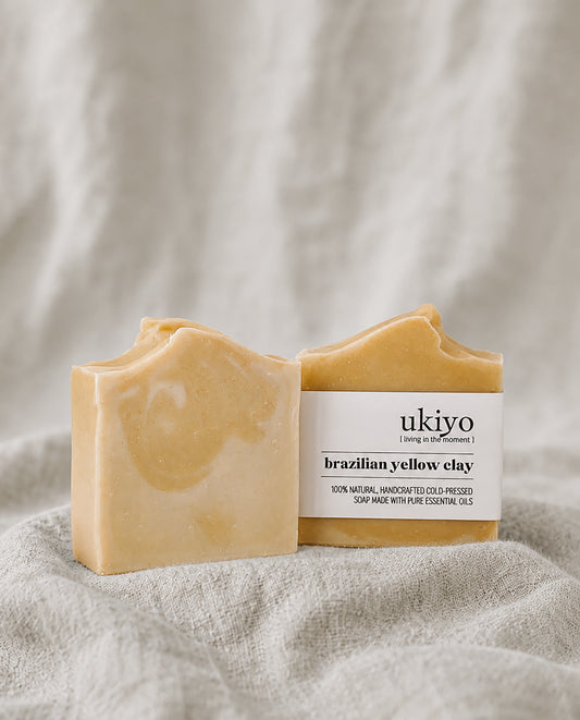 Two bars of Brazilian yellow clay soap with a 'ukiyo' label on a textured beige background